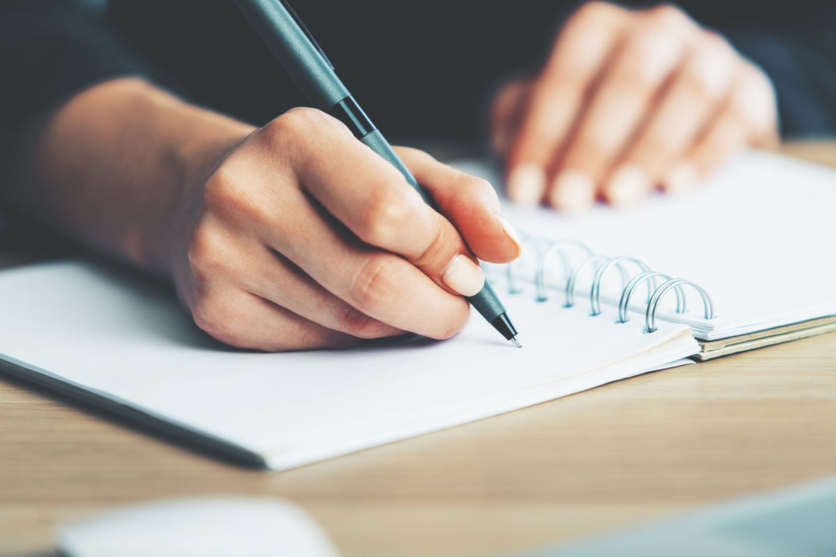 Person writing in a notepad