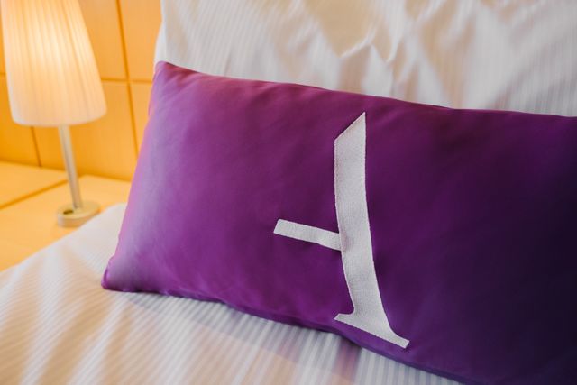 Close-up of an Ambassador Cruise line pillow on a bed