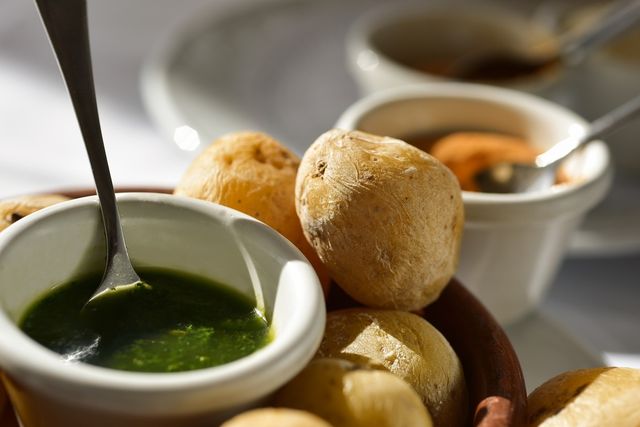 A plate of papas arrugadas served with mojo verde and mojo rojo