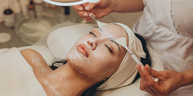 Woman receiving a facial treatment in a spa setting.