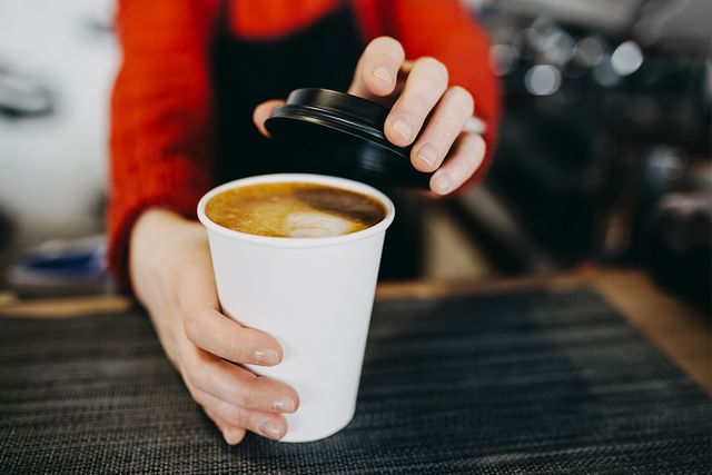 Barista handing over coffee cup