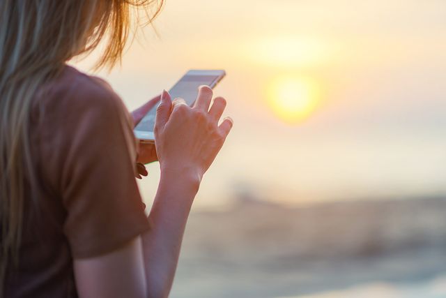 Women using app on the beach on holiday
