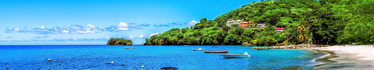 Calm blue sea with small boats, a sandy shoreline in Kingstown Saint Vincent