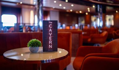 The cozy lounge with orange seating of the Cavern Bar on Ambition