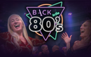 Two people joyfully dancing with a neon "Back to the 80's" sign in the background, featuring vibrant geometric shapes.