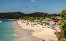Sandy beach in St Johns Antigua with colorful umbrellas and people relaxing