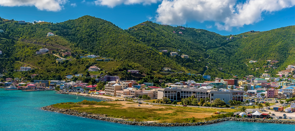 Road Town, Tortola with colorful buildings, nestled at the foot of green hills,
