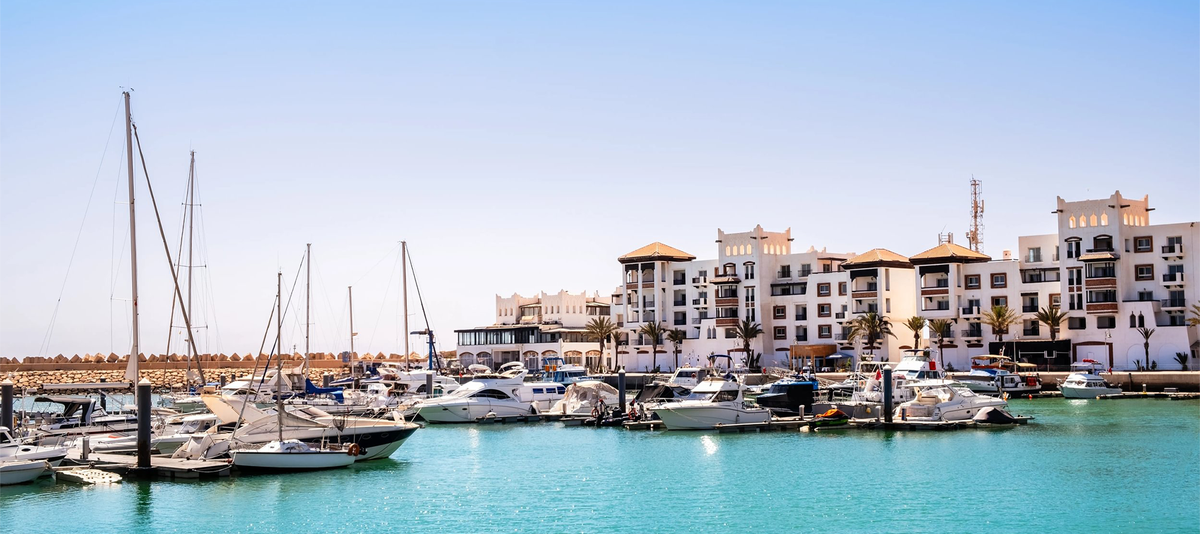 Agadir Marina in Morocco. Popular tourist area with luxury apartments, boats in harbor, shops and restaurants. Moroccan seaside resort on shore of Atlantic ocean in Africa