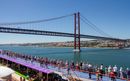 A busy top deck on Ambition cruise ship whilst sailing out of Lisbon under the bridge