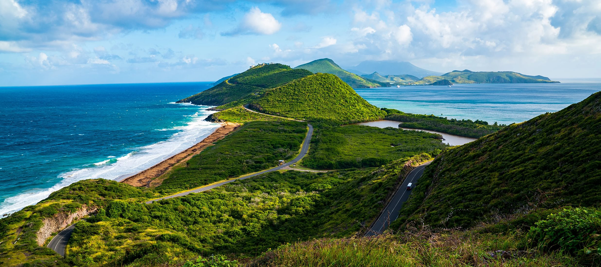 Basseterre, St Kitts with a winding road, green hills, and blue ocean