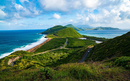 Basseterre, St Kitts with a winding road, green hills, and blue ocean