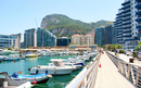 A view of a harbor filled with luxury ships under the Gibraltar Mountain.