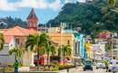 Street view of Kingstown, Saint Vincent with colorful buildings, palm trees and a backdrop of green hills