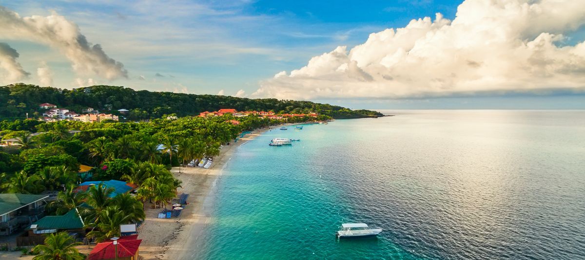 An aerial view of a tropical beach in Roatán Honduras early in the morning.