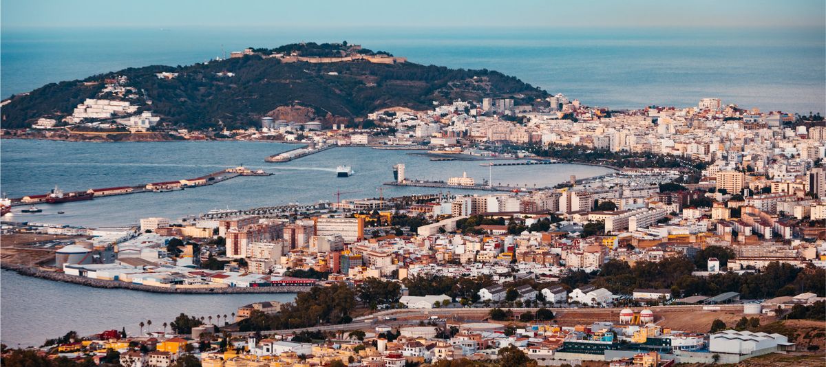 General view of the bay of Ceuta at sunset with Mount Hacho in the background while a ferry enters through the mouth of the port
